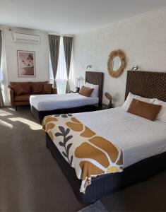a hotel room with two beds and a couch at Mallacoota Hotel Motel in Mallacoota +37 photos
