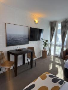 a living room with a table and a flat screen tv at Mallacoota Hotel Motel in Mallacoota