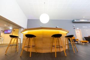 a bar with three stools and a yellow counter at Reykjavik Lights Hotel by Keahotels in Reykjavík +50 photos