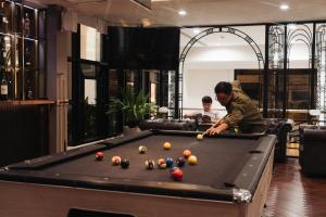 a man playing a game of pool in a living room at Kantary Hotel Banchang in Ban Chang
