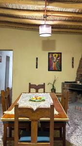 a wooden dining room table with chairs and a ceiling at By Lela in Tinogasta