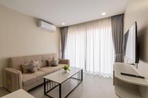 a living room with a couch and a tv at Walk Street Hotel & Apartment in Phnom Penh