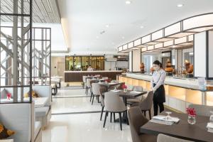 a man wearing a mask stands in a restaurant at Kantary Hotel Banchang in Ban Chang