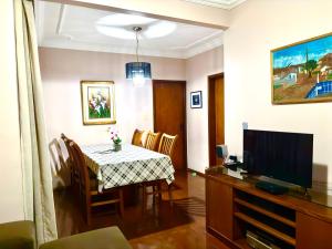a dining room with a table and a television at Apartamento Uberlândia - BH in Belo Horizonte