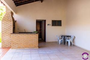 a patio with a table and chairs next to a wall at Pousada Casa Shanti in Dourados