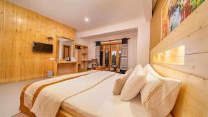 a bedroom with a large bed and a television at 3 Arch Resort Ella in Ella