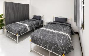 ein Schlafzimmer mit zwei Betten und Azeb in der Unterkunft ST Apartment in Dusit