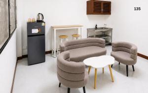ein Wohnzimmer mit Stühlen, einem Tisch und einer Theke in der Unterkunft ST Apartment in Dusit