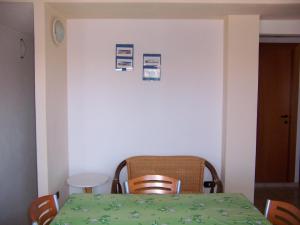une salle à manger avec une table et des chaises vertes dans l'établissement Casa Vacanza Marina di Arbus, à Torre Dei Corsari