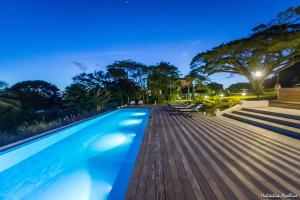 una piscina con terrazza in legno di notte di Apolline a Fort-de-France