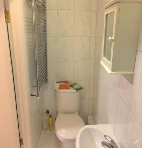 a white bathroom with a toilet and a sink at The Bungalow in London