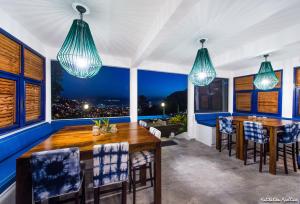 una sala da pranzo con un grande tavolo in legno e sedie blu di Apolline a Fort-de-France