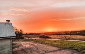 a sunset over a field with a barn at Stunning Apartment In Holstebro With Wifi in Holstebro