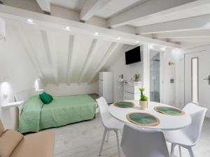 a white room with a bed and a table and chairs at Attic studio, with air conditioning in Castelsardo