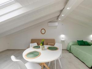 a white dining room with a white table and chairs at Attic studio, with air conditioning in Castelsardo