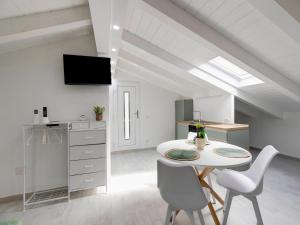 a living room with a white table and chairs at Attic studio, with air conditioning in Castelsardo