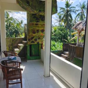 a room with a view of the ocean and palm trees at Pondok Diana 3 in Jasri +18 photos