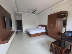 a bedroom with a bed and a tv in a room at Greenway Retreat Resort in Puducherry Airpoert