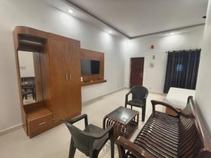 a living room with chairs and a flat screen tv at Greenway Retreat Resort in Puducherry Airpoert