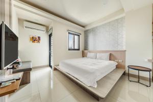 a bedroom with a bed and a tv at Jialai Homestay - Parking Available - Near Magong Center in Magong
