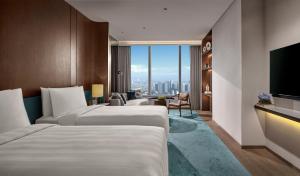 a hotel room with two beds and a television at Pan Pacific Jakarta in Jakarta +56 photos