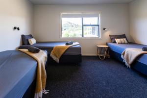 two beds in a room with a window at Port Jackson Paradise in Square Top Island