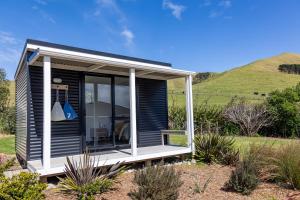 a black tiny house with a white porch at Port Jackson Paradise in Square Top Island