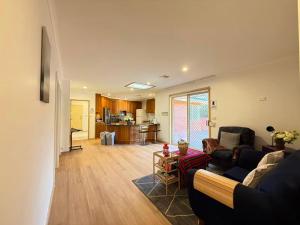 a living room with a couch and a kitchen at Central Private Room - Stroll to ANU & City in Turner