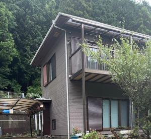 a house with a balcony on the side of it at Oyado Nishiki in Minamiizu