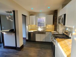 a kitchen with white cabinets and a sink and a stove at Updated cozy in central Cleveland in Cleveland