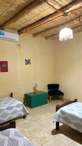 a room with two beds and a green table at By Lela in Tinogasta +8 photos