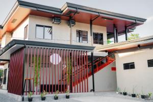 a house with a red gate in front of it at Luna Vista Tourist Inn in Puerto Princesa City
