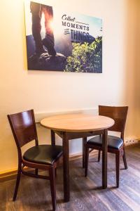 einen Tisch, zwei Stühle, einen Tisch und ein Bild in der Unterkunft Euro Youth Hotel Munich in München