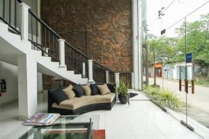 a living room with a couch and a staircase at Nathaliya Tourist Hotel in Seeduwa