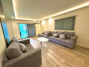 a living room with two couches and a table at La Gabbia Chalets in Al Kafrayn +1 photo
