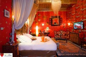 um quarto com uma cama grande e paredes vermelhas em Hôtel Renaissance em Castres