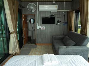 a living room with a couch and a tv in a rv at สกายวันเดอร์ ภูทับเบิก in Ban Tha Kok Hai