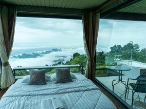 a bedroom with a bed and a large window at สกายวันเดอร์ ภูทับเบิก in Ban Tha Kok Hai +14 photos