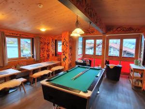 a room with a pool table in a restaurant at Alpking Hostel in Ellmau