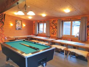 a room with a pool table and tables and benches at Alpking Hostel in Ellmau +21 photos
