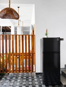 a black refrigerator sitting on a tile floor at Eastern Bay in Arugam Bay