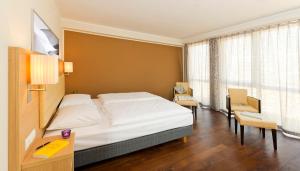 a hotel room with a bed and a table and chairs at Bonnox Boardinghouse & Hotel in Bonn