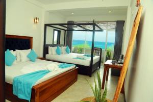 a bedroom with two beds and a view of the ocean at Cozy Cocos Midigama in Ahangama