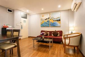 ein Wohnzimmer mit Sofa und Tisch in der Unterkunft CBD Hotel Suratthani in Surat Thani