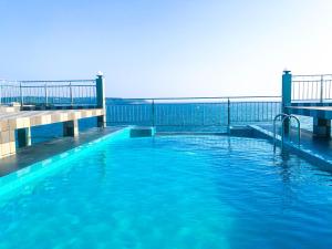 a swimming pool with blue water and a pier at Hotel Sea Line in Galle