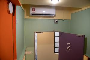 a room with a refrigerator with a number two on it at Bestow Capsule Hostel in Kuala Lumpur