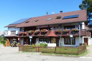 una casa con cajas de flores y una valla en Mettenberger Hof - Pension, en Grafenhausen