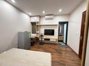a room with a kitchen with a refrigerator and a television at Sơn Tài in Hanoi
