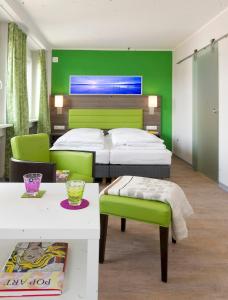 ボンにあるボノックス ボーディングハウス ＆ ホテルの緑の壁、ベッド付きのベッドルーム1室