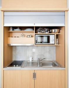 a kitchen with a sink and a microwave at Bonnox Boardinghouse & Hotel in Bonn